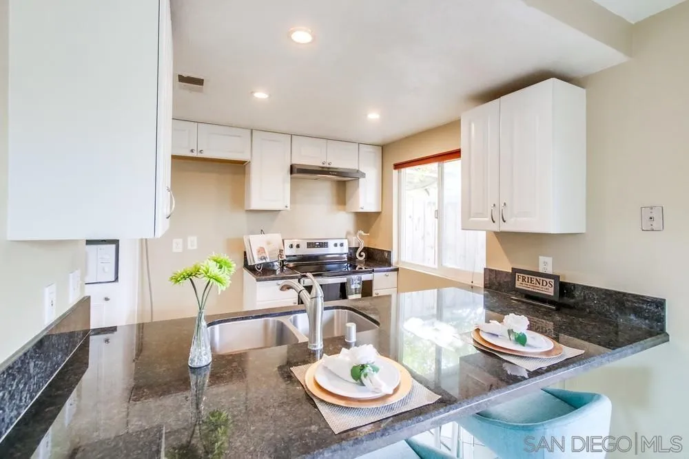 933 Greenfield Drive, Unit D El Cajon, CA 92021 - Photo 11 of 41 a kitchen with stainless steel appliances a dining table and chairs