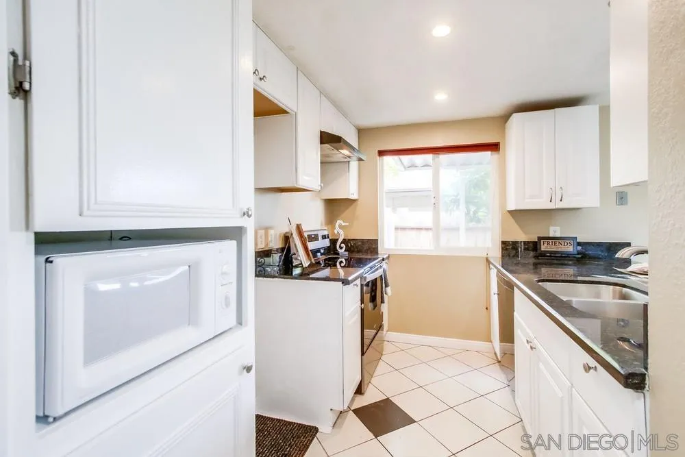 933 Greenfield Drive, Unit D El Cajon, CA 92021 - Photo 16 of 41 a kitchen with granite countertop a sink a counter space appliances and cabinets