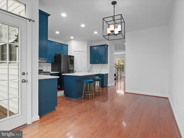 a kitchen with kitchen island granite countertop stainless steel appliances refrigerator cabinets dining table and chairs