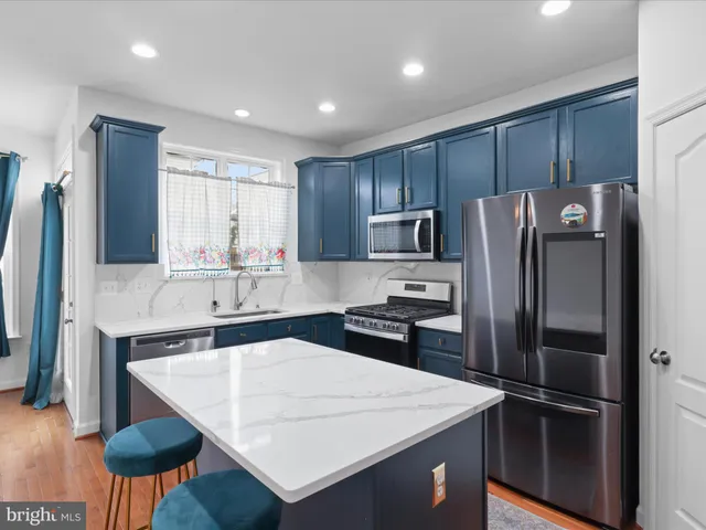 a kitchen with a refrigerator a sink and wooden cabinets