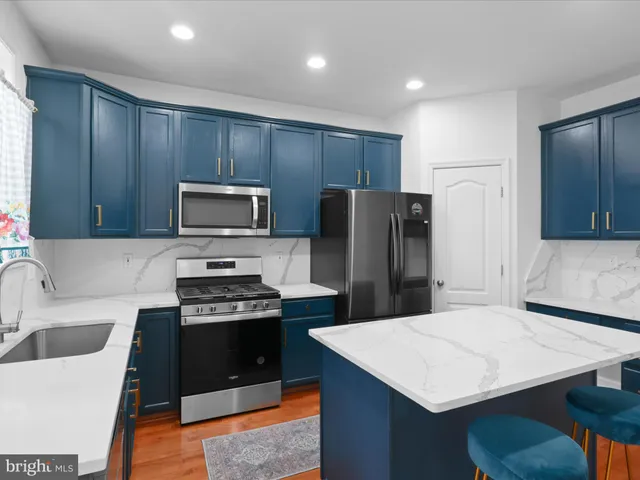 a kitchen with a refrigerator a sink a stove and cabinets
