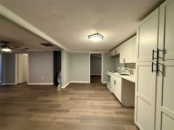 a large white kitchen with stainless steel appliances granite countertop a refrigerator and a stove top oven