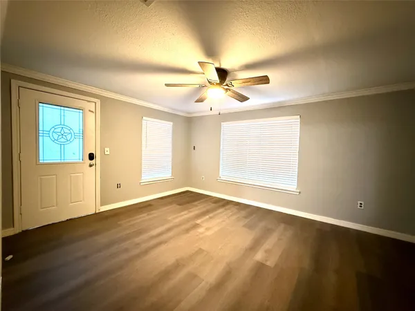 an empty room with wooden floor and windows