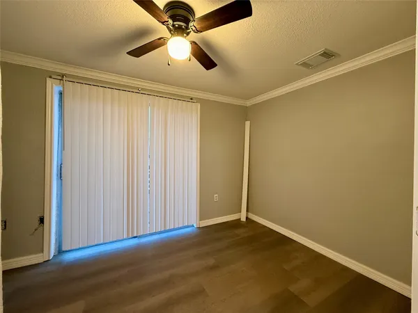 an empty room with a ceiling fan and a window