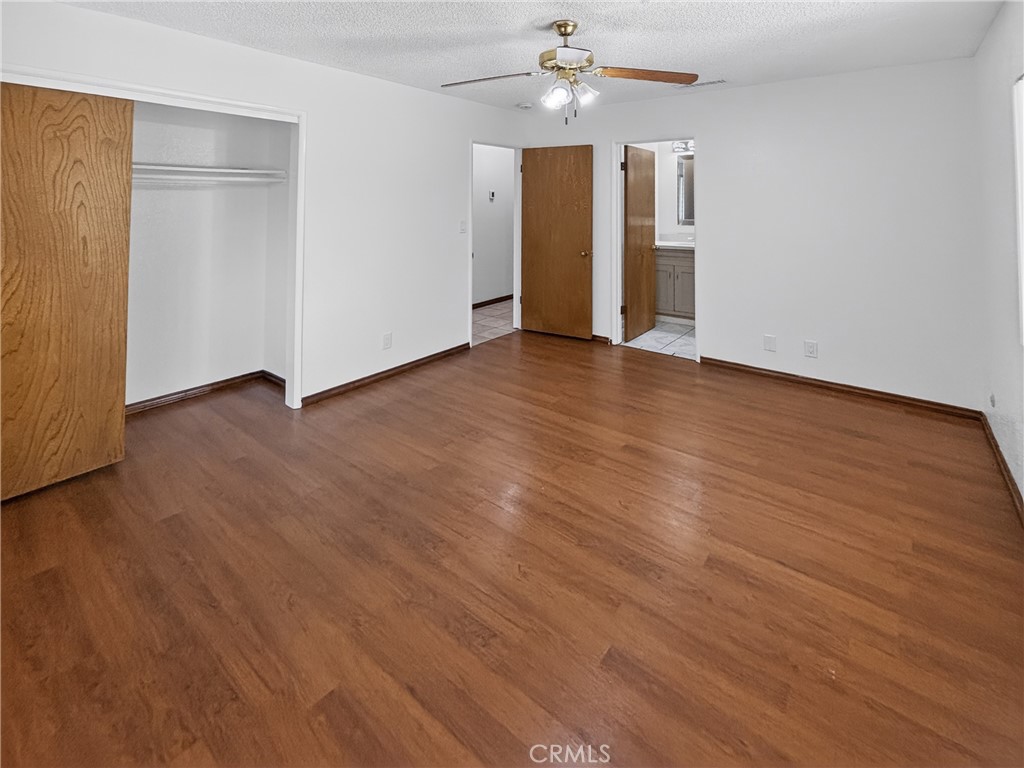 7451 Diamond Street Riverside, CA 92504 - Photo 16 of 31 an empty room with wooden floor and ceiling fan