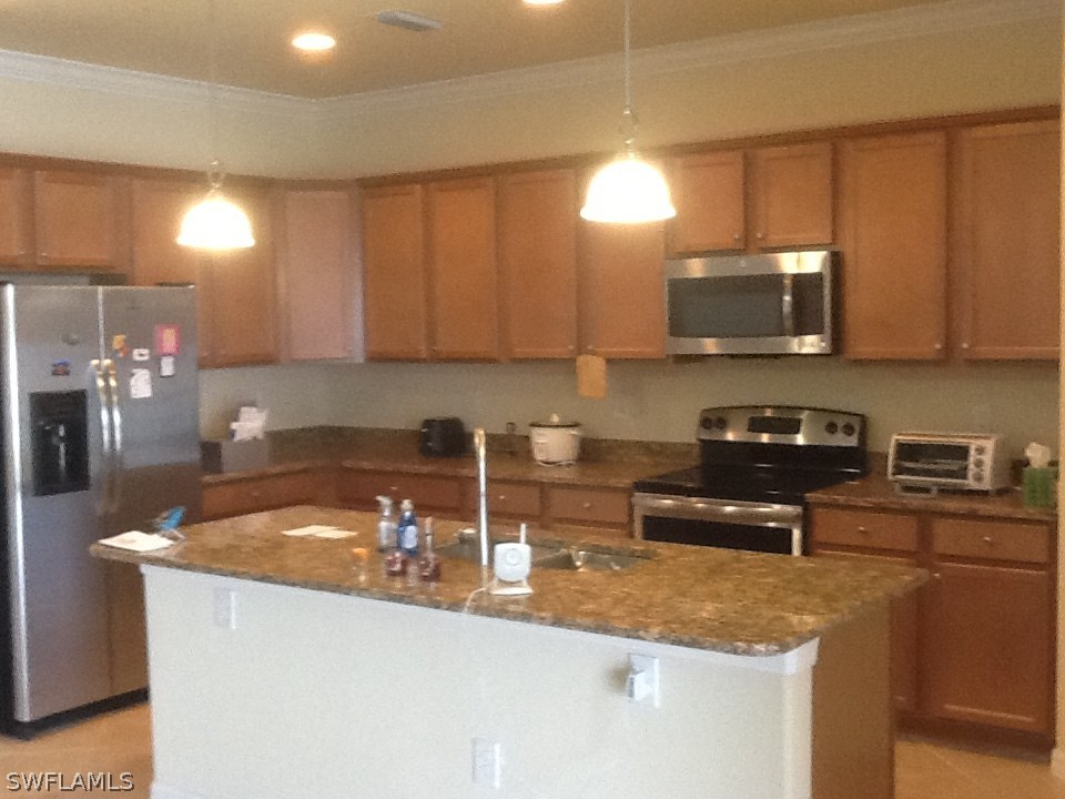 11672 Eros Road Lehigh Acres, FL 33971 - Photo 4 of 18 a kitchen with granite countertop a sink a stove a microwave a refrigerator and cabinets