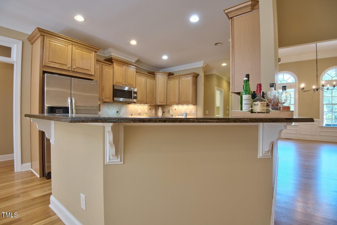 2919 Reynolda Circle Durham, NC 27712 - Photo 27 of 58 a kitchen with stainless steel appliances granite countertop a sink a refrigerator and a granite counter tops with wooden floors