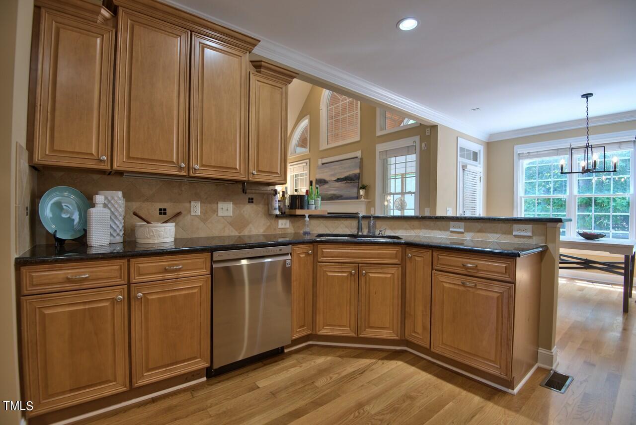 2919 Reynolda Circle Durham, NC 27712 - Photo 29 of 58 a kitchen with stainless steel appliances granite countertop a sink a stove cabinets and wooden floor