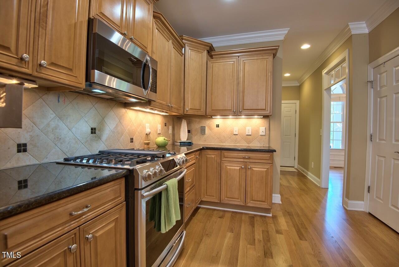 2919 Reynolda Circle Durham, NC 27712 - Photo 30 of 58 a kitchen with stainless steel appliances granite countertop a stove a sink and a microwave