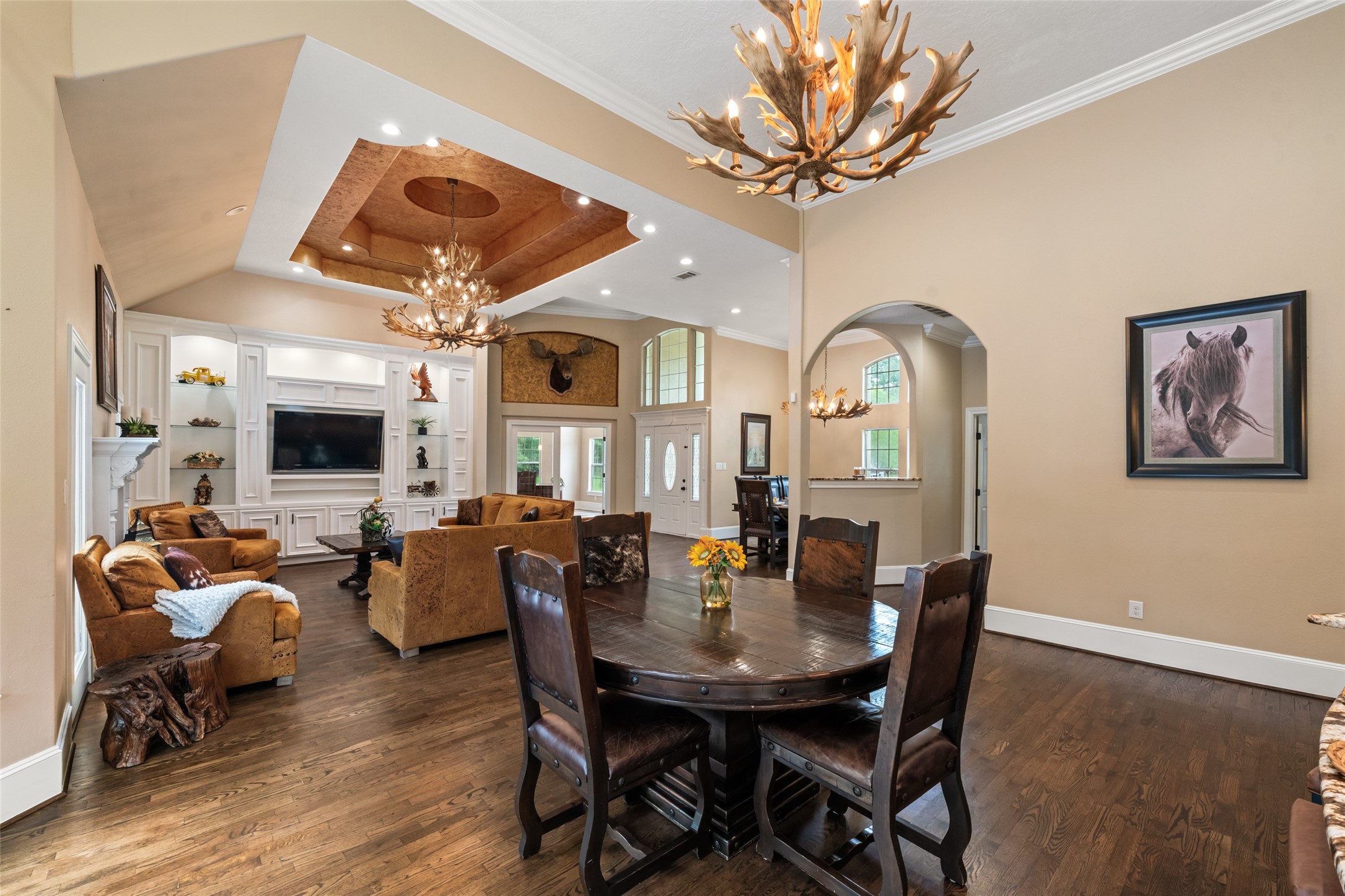 32660 Willow Bend Road Waller, TX 77484 - Photo 7 of 47 Inviting dining space highlighted by a statement chandelier, warm wood flooring, arched openings, and views into the adjoining living area.