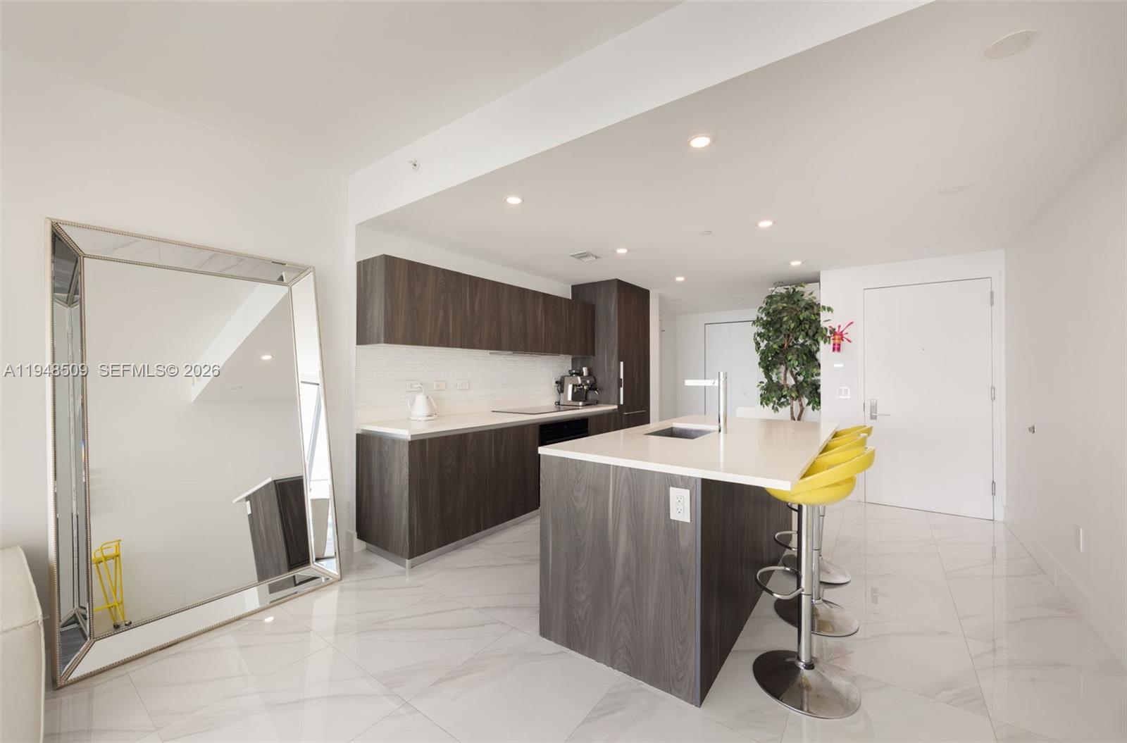 3131 Northeast 7th Avenue, Unit 1902 Miami, FL 33137 - Photo 4 of 15 a view of kitchen with kitchen island stainless steel appliances refrigerator stove microwave and cabinets