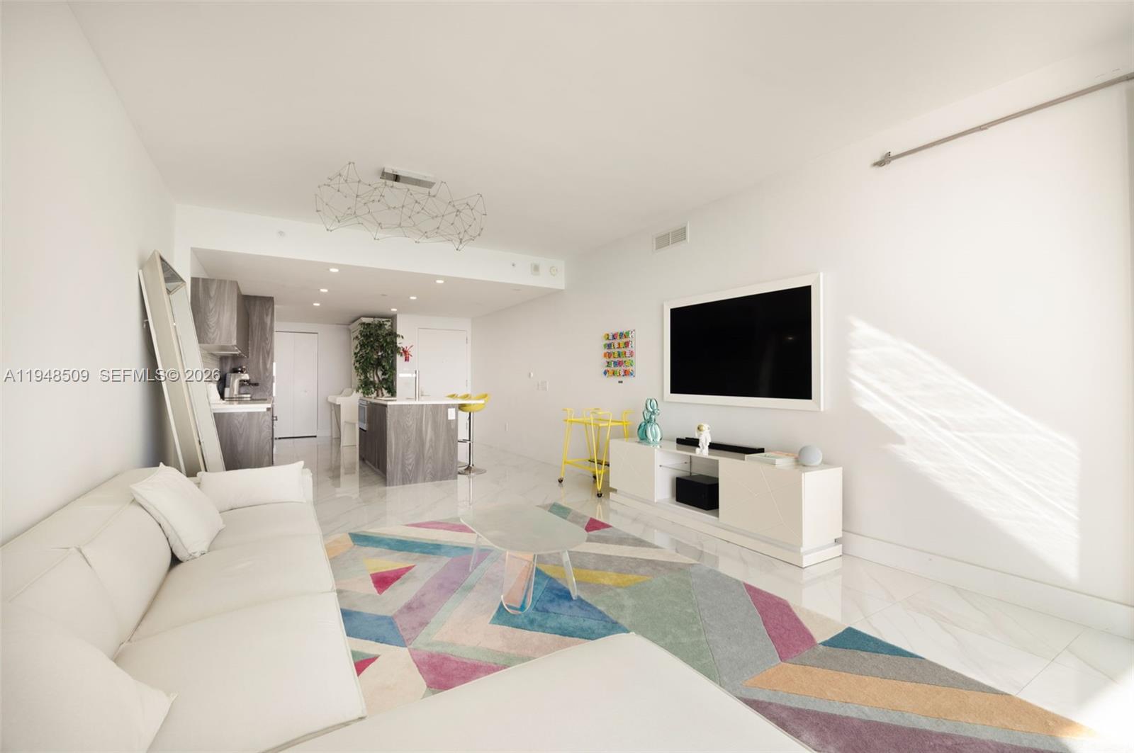 3131 Northeast 7th Avenue, Unit 1902 Miami, FL 33137 - Photo 7 of 15 a living room with furniture and a flat screen tv