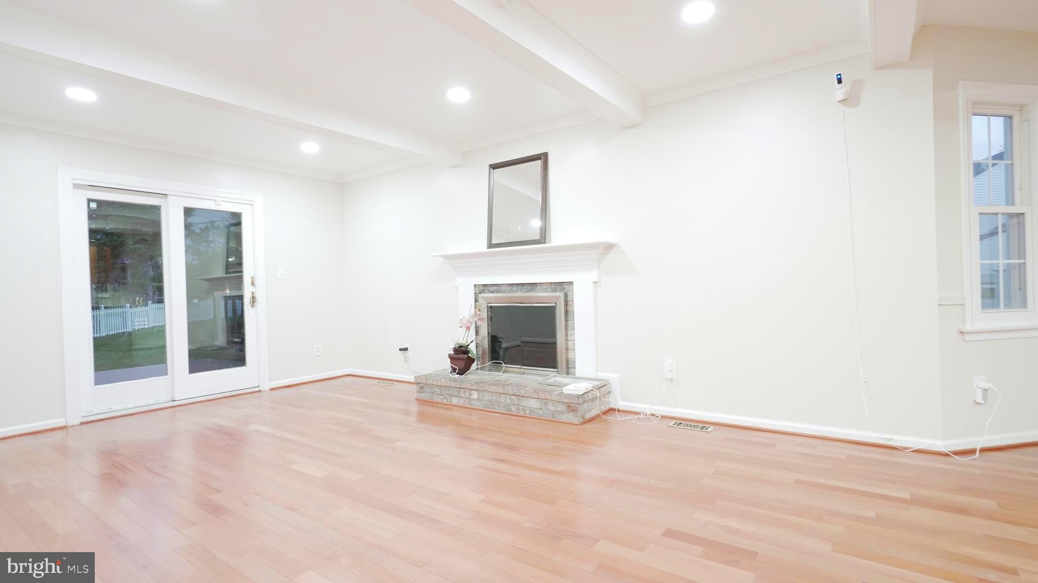 10203 Raleigh Tavern Lane Ellicott City, MD 21042 - Photo 19 of 57 a view of an empty room with a fireplace and a window