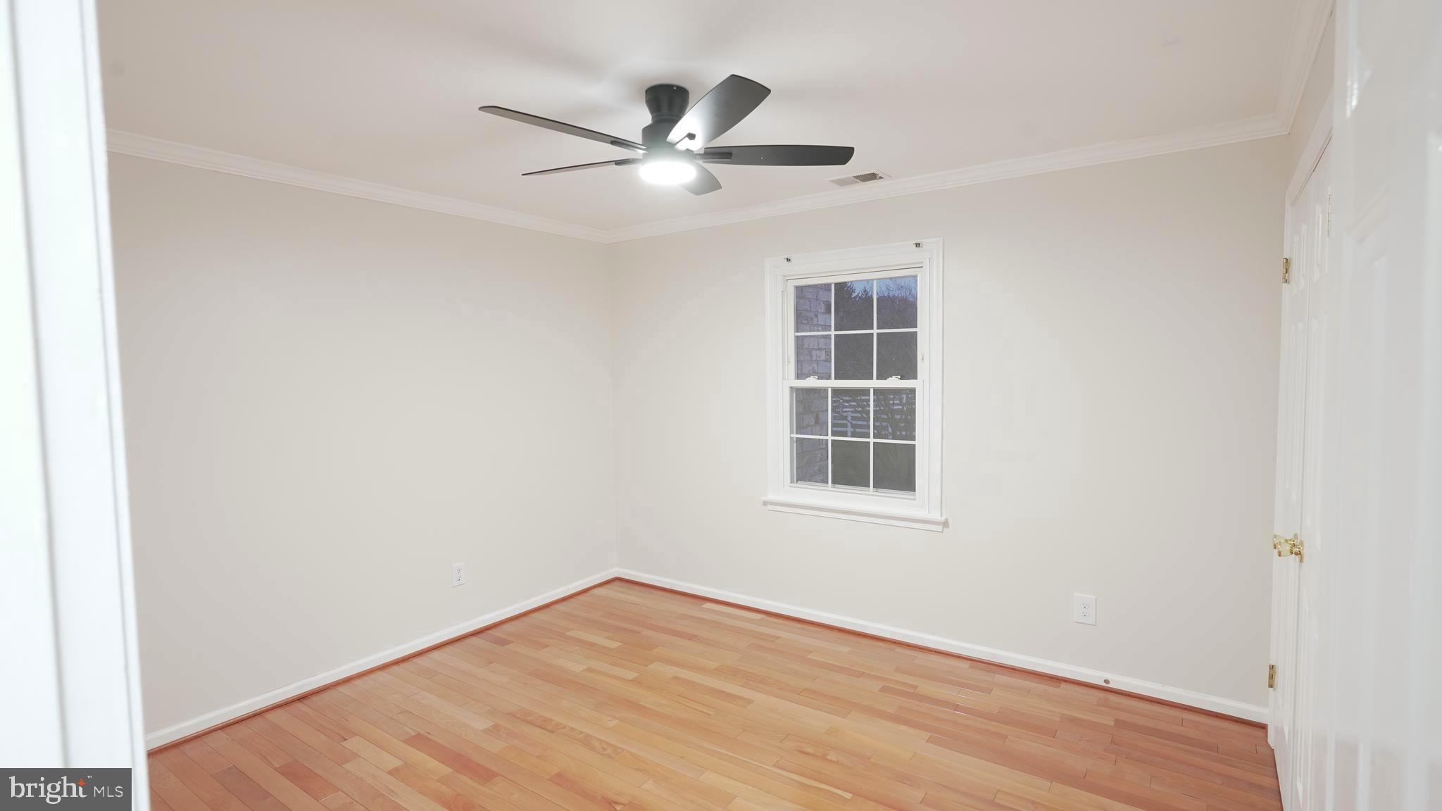 10203 Raleigh Tavern Lane Ellicott City, MD 21042 - Photo 37 of 57 an empty room with wooden floor fan and windows