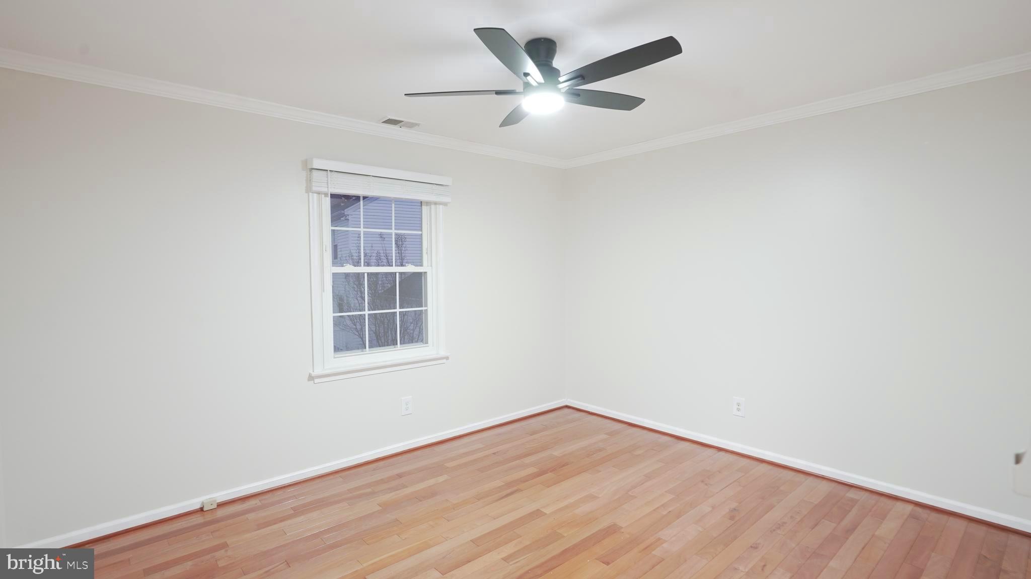 10203 Raleigh Tavern Lane Ellicott City, MD 21042 - Photo 38 of 57 an empty room with wooden floor and windows