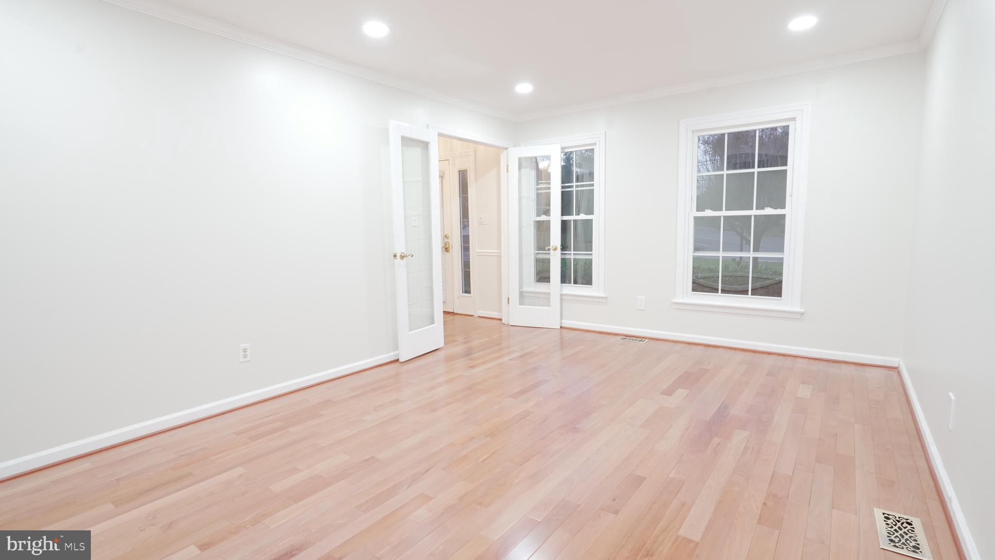 10203 Raleigh Tavern Lane Ellicott City, MD 21042 - Photo 9 of 57 an empty room with wooden floor and windows