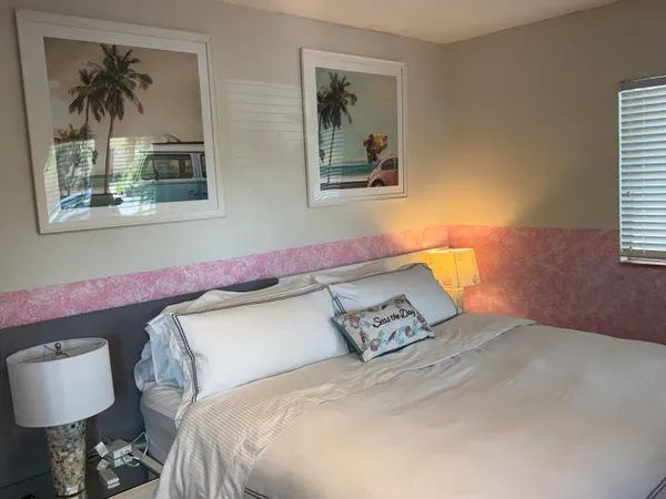a bedroom with a bed and a painting on the wall