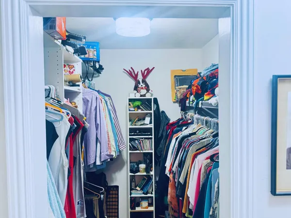 a view of walk in closet with clothes