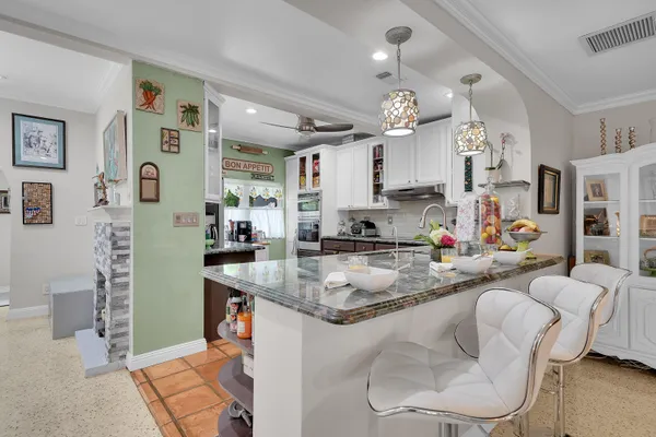 a kitchen with cabinets and chairs