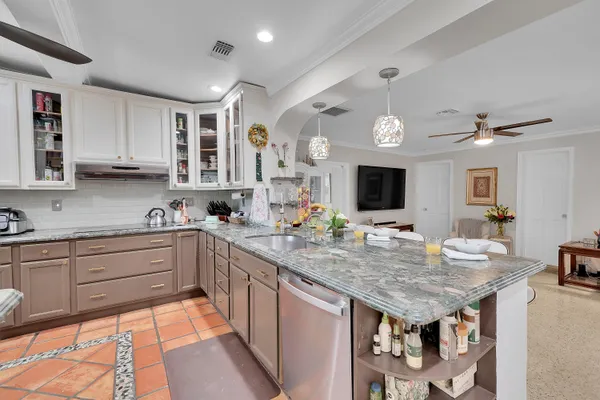 a kitchen with granite countertop a sink and cabinets