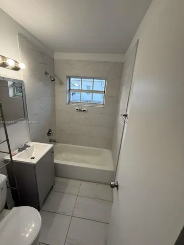 a white toilet sitting next to a bath tub