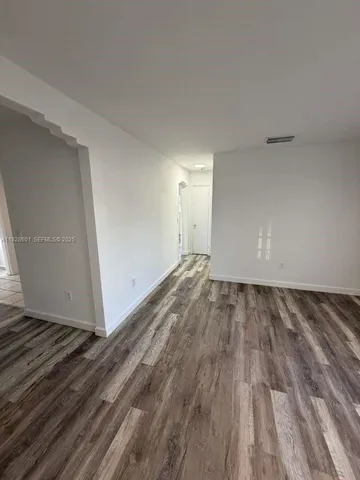 a view of an empty room and wooden floor