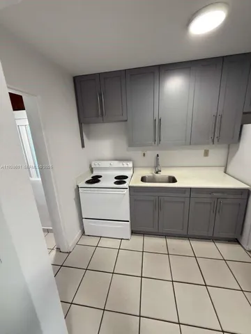 a kitchen with a sink a stove and cabinets