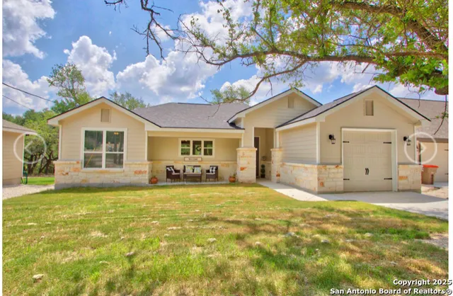 a view of a house with a yard and large tree