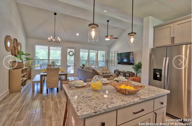 a view of a dining room and livingroom with furniture wooden floor a chandelier