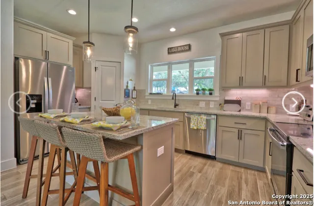a kitchen with kitchen island granite countertop a sink stove and cabinets