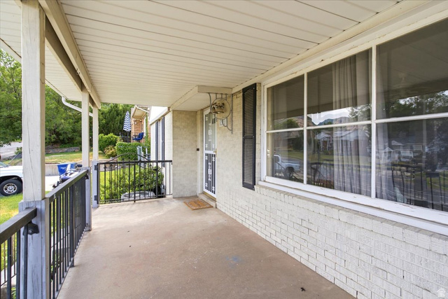 1341 29th Street Ogden, UT 84403 - Photo 4 of 37 Covered front porch featuring a concrete surface, black metal railing, and white painted brick exterior