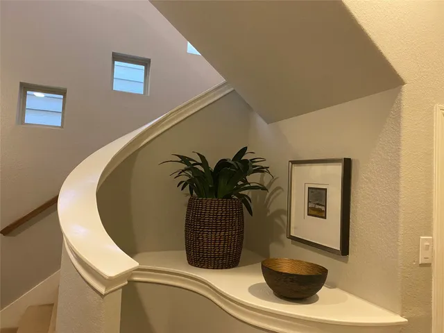 a view of staircase with railing and white walls