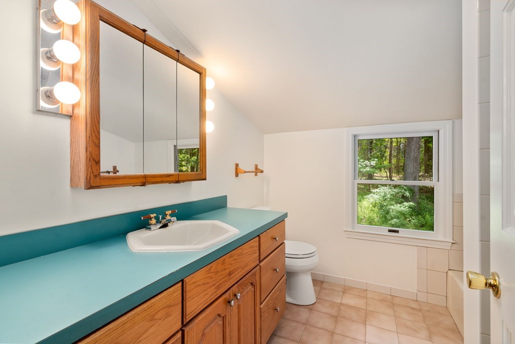 24 Granison Road Weston, MA 02493 - Photo 16 of 30 a bathroom with a sink toilet a mirror and window