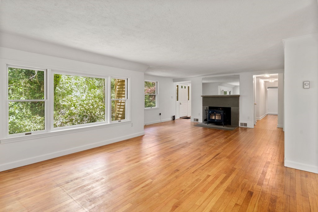 24 Granison Road Weston, MA 02493 - Photo 4 of 30 an empty room with wooden floor a fireplace and windows