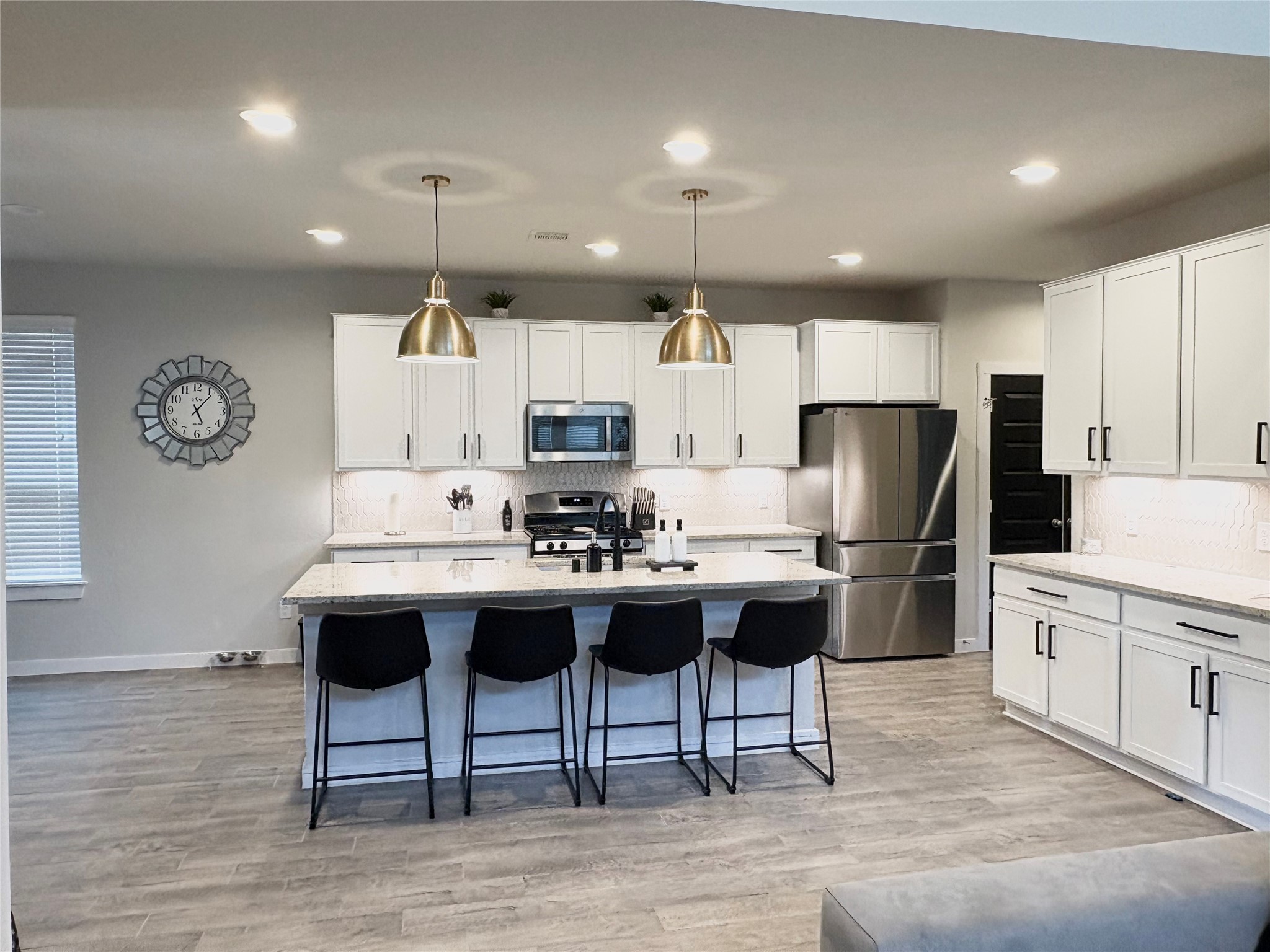 2142 Reed Cave Lane Spring, TX 77386 - Photo 3 of 15 a kitchen with stainless steel appliances kitchen island a table chairs refrigerator and microwave