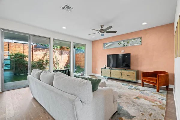 a living room with furniture a flat screen tv and a large window
