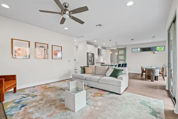 a living room with furniture and a view of kitchen