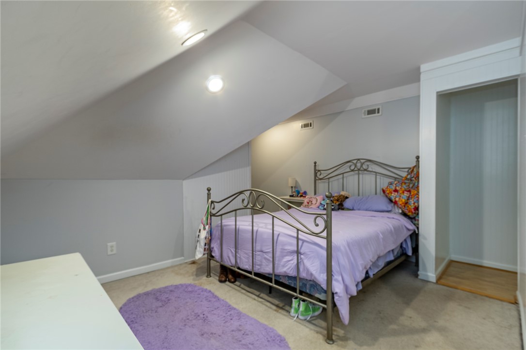 151 Hannah Circle Anderson, SC 29621 - Photo 32 of 46 This cozy bedroom features a sloped ceiling and comfortable carpeting, offering a unique and inviting atmosphere.