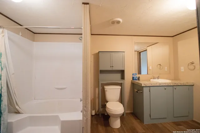 a bathroom with a granite countertop sink toilet and shower