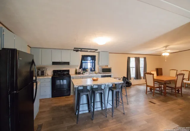 a kitchen with stainless steel appliances a table and chairs