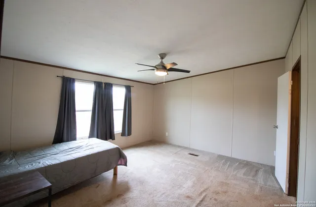 a bedroom with a large bed and a chandelier