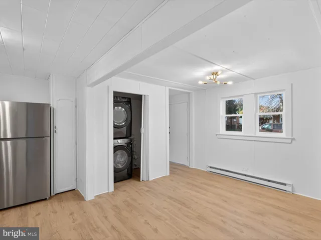 a view of an empty room with closet and a window