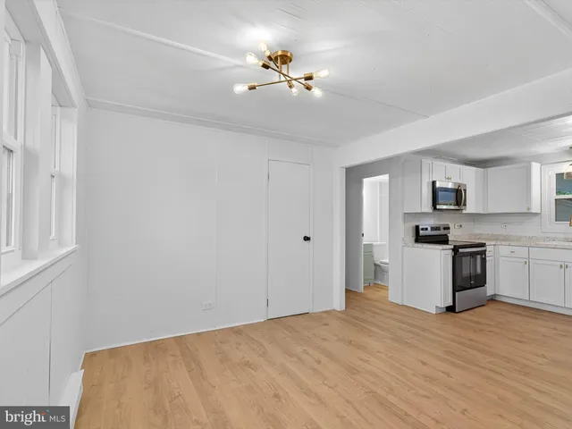 a view of a kitchen with a sink a ceiling fan and kitchen view
