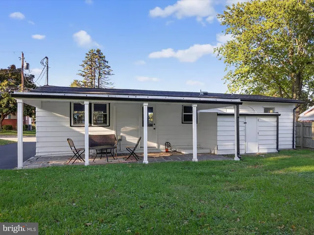 a view of a house with a yard and sitting area