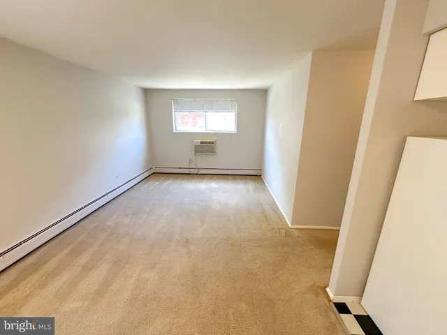 a view of empty room with kitchen