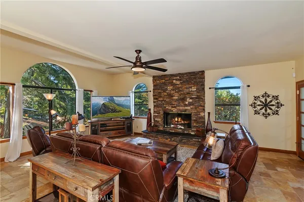 a living room with furniture a fireplace and a floor to ceiling window