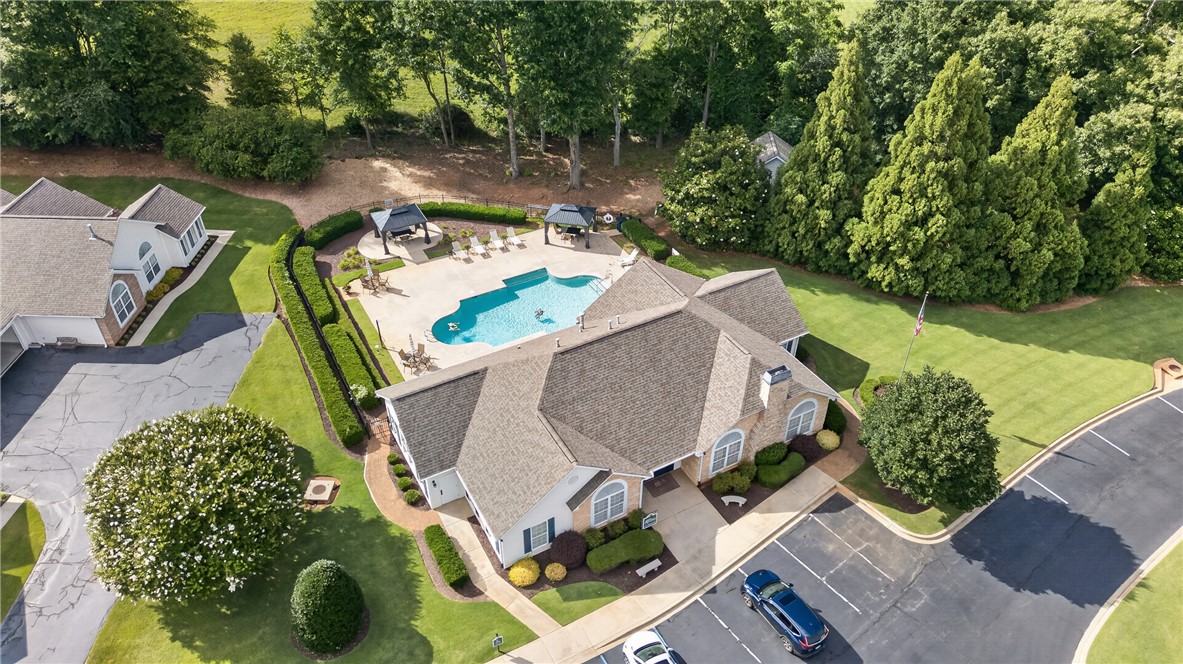 134 Life Style Lane Anderson, SC 29621 - Photo 43 of 44 An aerial perspective reveals a private pool with ample sunbathing areas, nestled beside a stately structure with abundant landscaping.