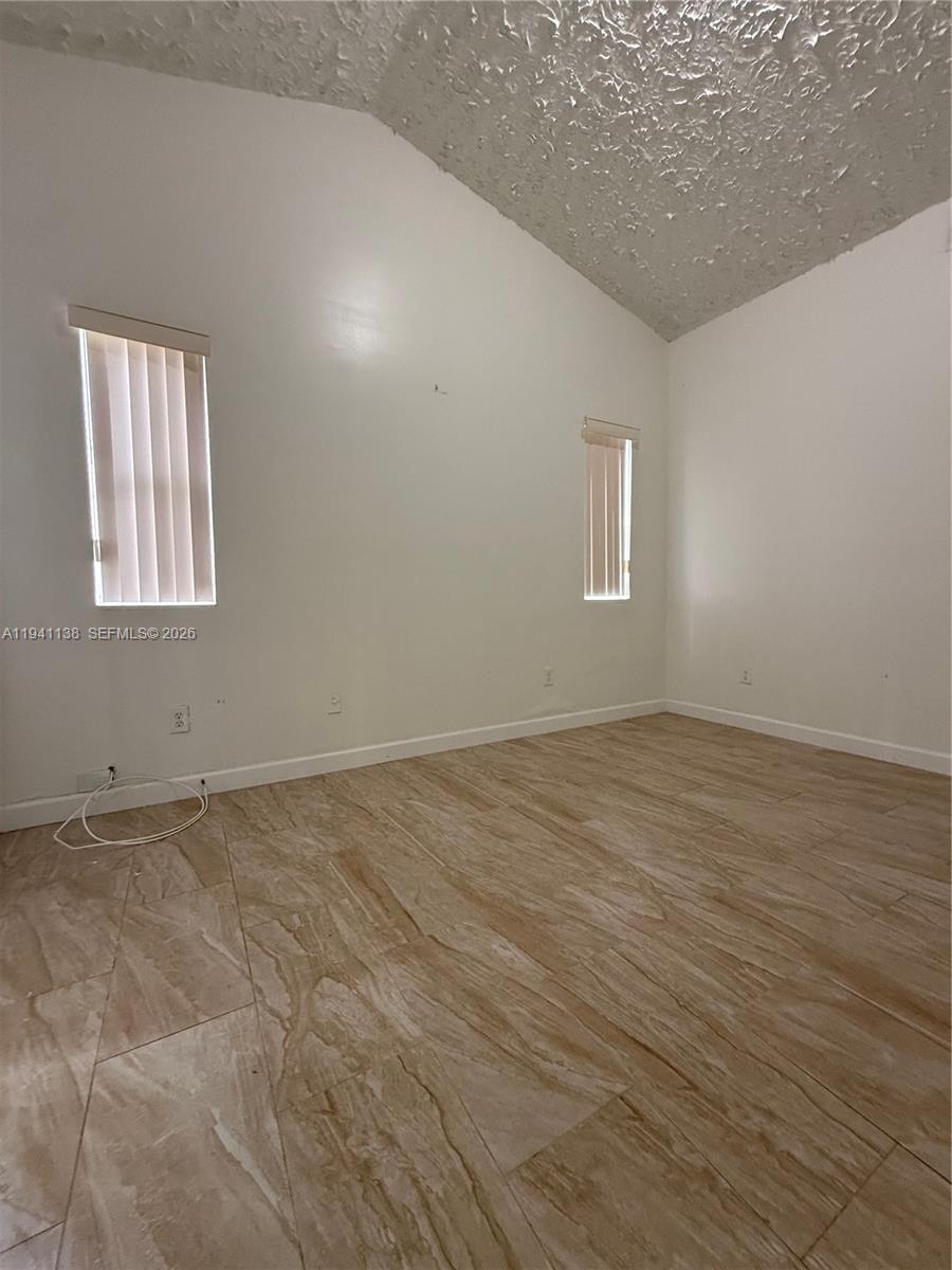 13628 Southwest 287th Lane Homestead, FL 33033 - Photo 13 of 17 an empty room with wooden floor and windows