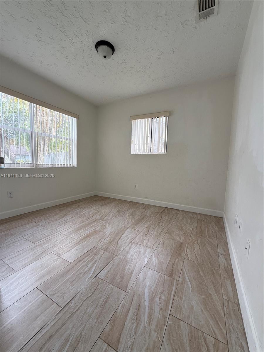 13628 Southwest 287th Lane Homestead, FL 33033 - Photo 14 of 17 an empty room with wooden floor and windows