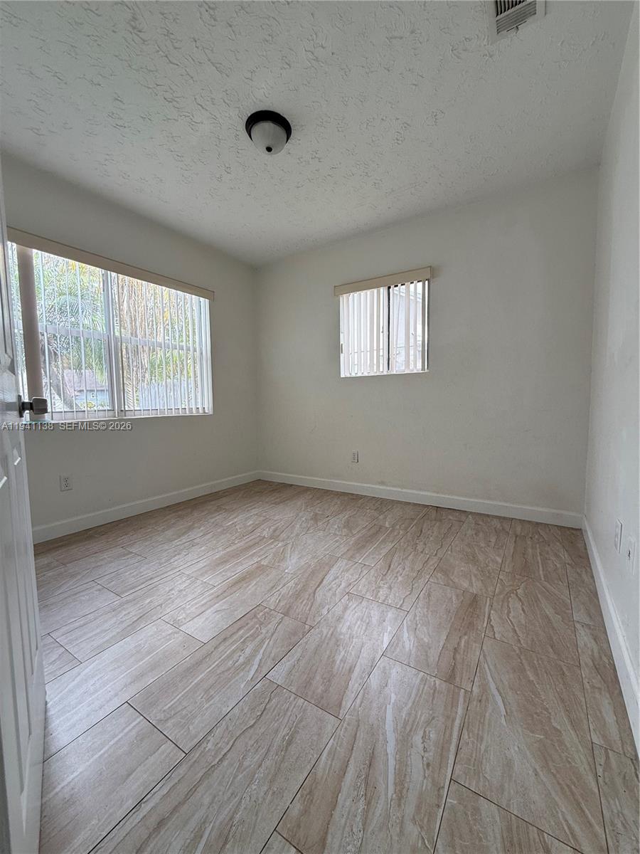 13628 Southwest 287th Lane Homestead, FL 33033 - Photo 15 of 17 wooden floor in an empty room with a window